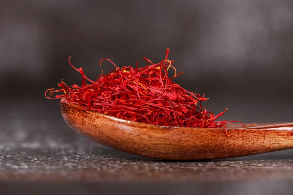 A small mound of dried saffron in a wooden spoon.