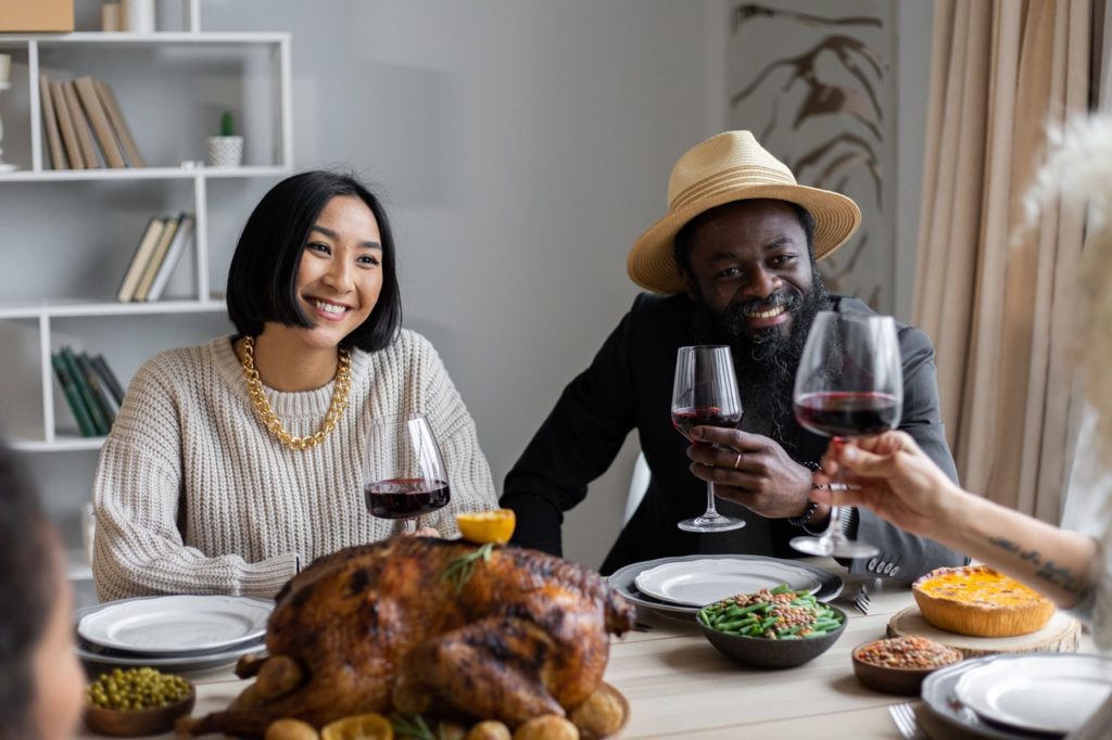 couple sitting at a dinner table with wine and roast chicken, highlighting the basics of food and wine pairing